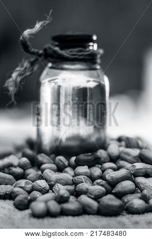 [arachis Hypogaea] Raw Groundnut In A Clay Bowl With Groundnut Oil On A Gunny Background.;