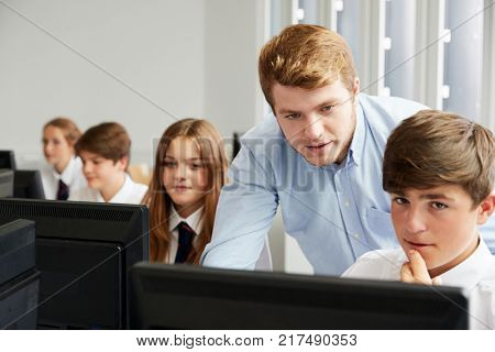 Teenage Students Wearing Uniform Studying In IT Class