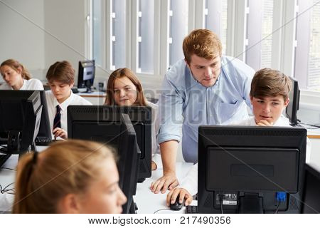 Teenage Students Wearing Uniform Studying In IT Class