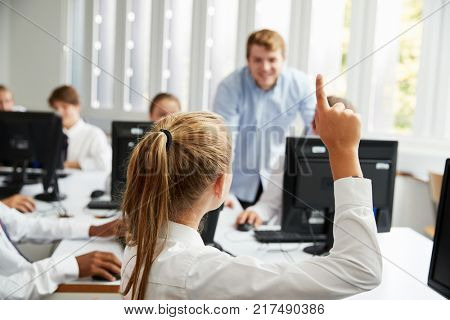 Teenage Students Asking Teacher Question In IT Class