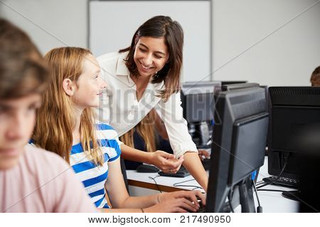 Teenage Students Studying In IT Class With Female Teacher