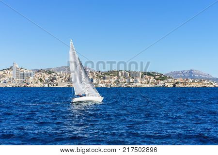 Sailing in the wind through the waves at the Sea, Marseille on background