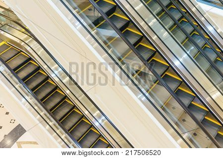 Escalator in Community Mall Shopping Center. Moving up staircase. electric escalator. Close up to escalators. Close up floor platform. yellow bands. metal line steel. yellow gray steel line.