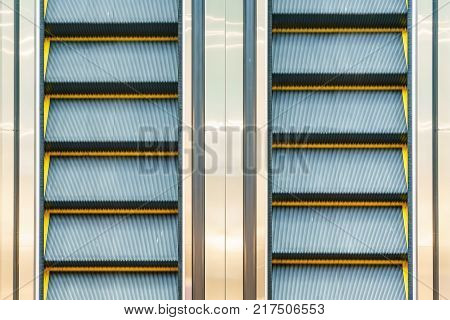 Escalator in Community Mall Shopping Center. Moving up staircase. electric escalator. Close up to escalators. Close up floor platform. yellow bands. metal line steel. yellow gray steel line.