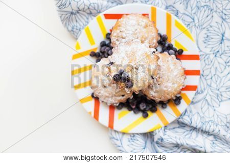 Blueberry muffins on plate and bright floral napkin, close-up