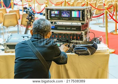 Sound technician and lights technicians control the music show in concert.Professional audio light mixer controller panel.Pro equipment for concerts.Stage lighting control.Hand adjusting audio mixer