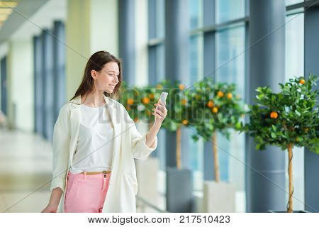 Young woman in international airport walking with her luggage.