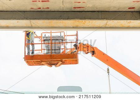 Hydraulic mobile construction platform elevated towards a blue sky with construction workers