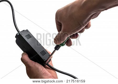 The man turns the screw on the power supply unit with a screwdriver.