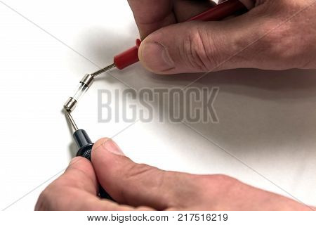 The man tests the integrity of the fuse. Hands close-up.