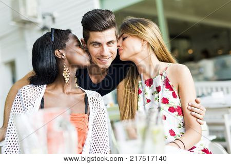 Happy young friends smiling outdoors being close to each other on a summer day