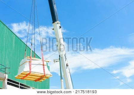 Industrial Crane operating and lifting a machine and equipment sunlight and blue sky