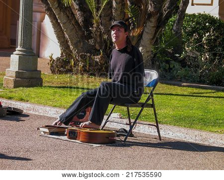 SAN DIEGO CALIFORNIA - MARCH 12 2007: Disabled armless person plays on guitar by his toes in Balboa Park in San Diego California on March 12 2007.
