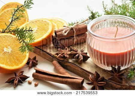 fresh oranges with anisestars, cinnamon sticks, juniper branches and aroma candle, Christmas time composition