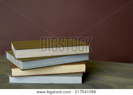 Four stamp albums books bunch on wooden table and bordeaux background