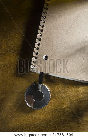 Stethoscope of a doctor in a notebook on a wooden table