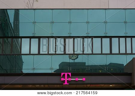 BERLIN, GERMANY - DECEMBER 05: The logo of a Telekom shop on the modern glass facade of a department store on Berlin's Alexanderplatz on December 05, 2017 in Berlin.