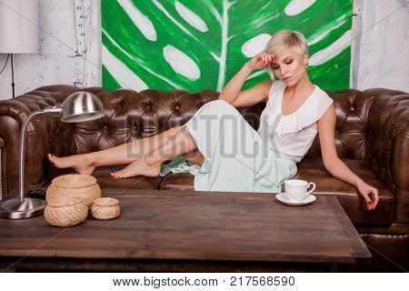 Beautiful Woman Sitting On Leather Sofa