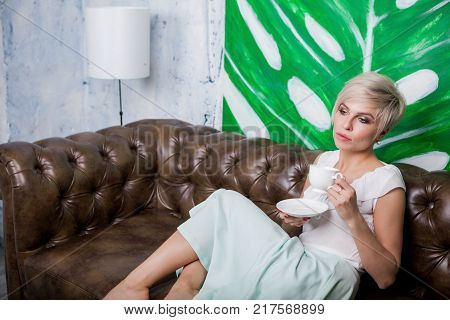 Beautiful Woman Sitting On Leather Sofa