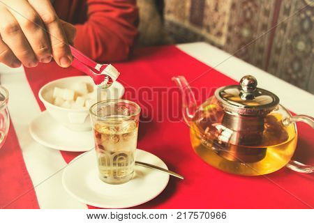 man puts sugar in tea restaurantEast style