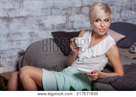 Beautiful Woman Sitting On Leather Sofa