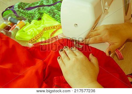 processes of sewing on the sewing machine sew women's hands sewing machine. Female tailor threading leather material on sewing machine. designer making a garment in her workplace
