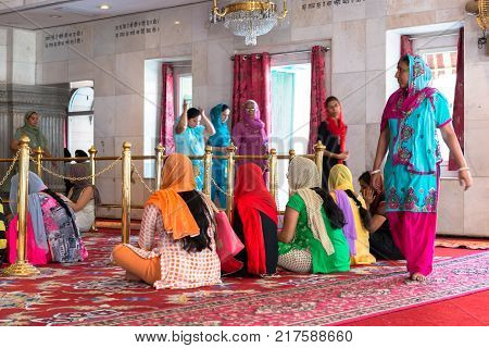 NEW DELHI INDIA - MARCH 18 2016: Horizontal picture of indian people of Sikh religion praying inside Gurudwara Sisganj Sahib located in New Delhi India.