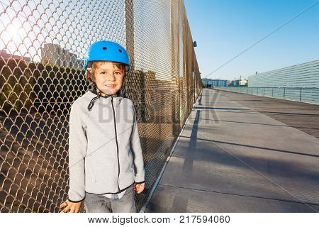 Close-up portrait of sporty boy in roller helmet, practicing at outdoor rollerdrom