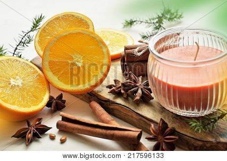 fresh oranges with anisestars, cinnamon sticks, juniper branches and aroma candle, Christmas time composition