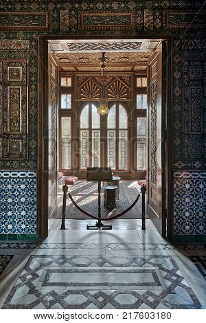 Cairo Egypt - December 2 2017: Manial Palace of Prince Mohammed Ali. Entrance of a small room at reception hall with ornate wooden wall and ceiling decorated wooden windows lantern and ornate marble floor