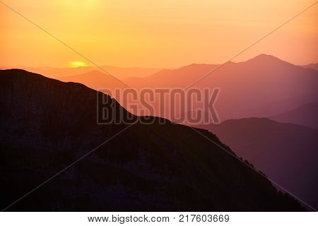 Beautiful sunset or sunrise in mountains in yellow orange and ultraviolet colours