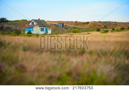 Old single russian house on a meadow in the end of summer