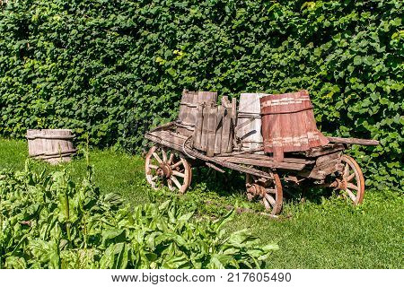 Old wooden cart telega on grass at summer