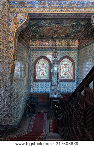 Cairo Egypt - December 2 2017: Wooden staircase decorated wooden balustrade Turkish ceramic tiles wall ornate ceiling stained glass windows Residence hall at Manial Palace of Prince Mohammed Ali