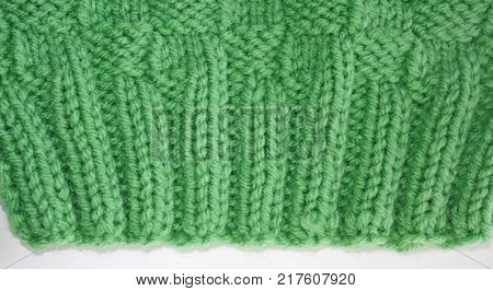 Close up of the knitted Rib Stitch.  Knit two, purl two, knit two, purl two in a pretty green color wool.  Then knitted in a Basket Weave stitch