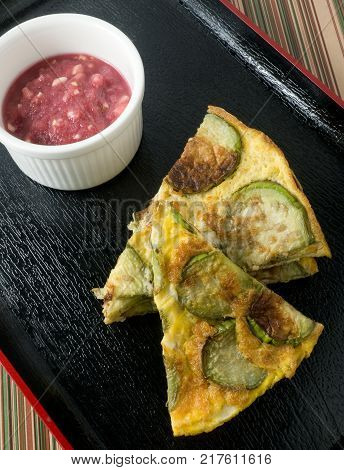 Thai Cuisine and Food Delicious Green Eggplant Omelet Served with Spicy Shrimp Paste Dip on A Black Tray.