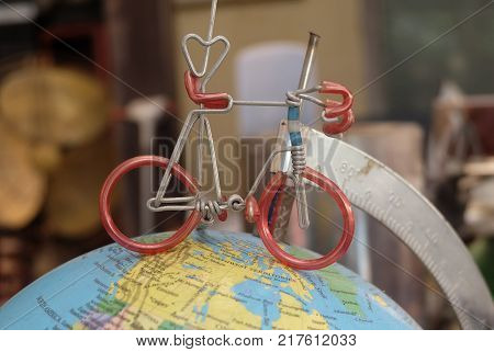 Miniature Bicycle Figure on Geography Globe or Planet Sphere Model Cyling to Destination.
