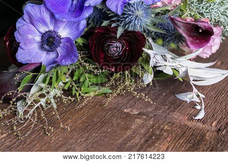flower arrangement, decoration, wedding concept. three absolutely different in sizes, colours and forms flowers such as anemons, persian battercups and lilies are composed one harmonious bunch