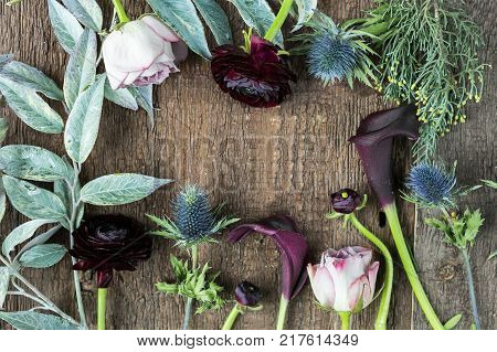 ecology, enveronmental friendly, background concept. buds of different flowers and leaves of various plants composed a frame on the textured surface of wooden table