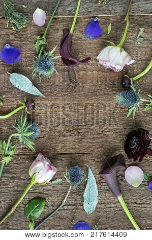 interior decoration, presents, lifestyle concept. beautiful flowers from garden that are arranged, they compose a frame of round form on the wooden background of desk