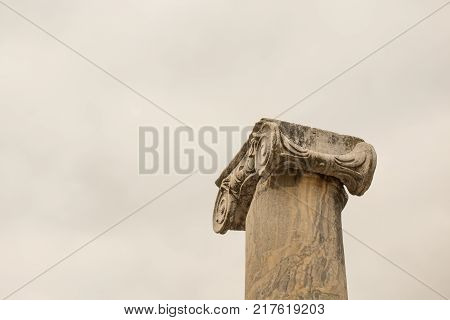 Upper Part Of The Marble Column With Carved Stonework In Ancient Town.