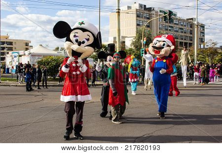 CAGLIARI, ITALY - DECEMBER 8, 2017: Village and parade of Santa Claus in Viale Bonaria - Sardinia (wading jugglers and Disney mascot)