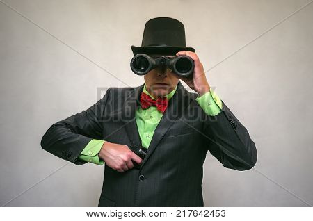 Spy. Secret detecive agent holds binoculars in his hands and looks through him isolated. Retro gangster.