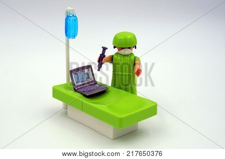 Amsterdam, The Netherlands-  December 10, 2017: Playmobil doctor injecting antivirus in a vires infected computer.