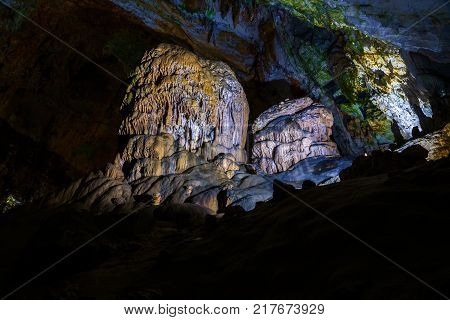 Postojna cave, Slovenia. Formations inside cave with stalactites and stalagmites. Low light image.