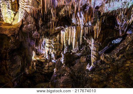 Postojna cave, Slovenia. Formations inside cave with stalactites and stalagmites. Low light image.
