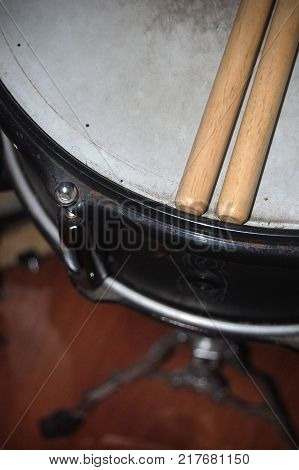 Closeup shot of a pair of drumsticks atop a drum.