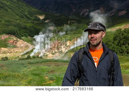Tourist in the background of famous Valley of Geysers. Kronotsky Nature Reserve on Kamchatka Peninsula.