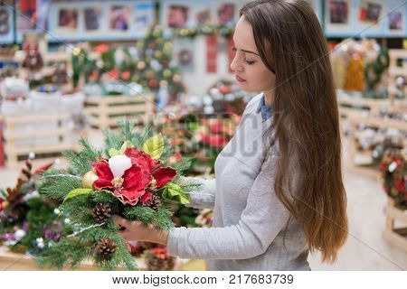 customergirl taking Christmas decorations. Various choice of New Year's wreath with decorations