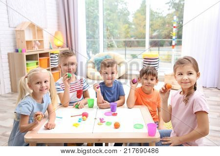 Little children engaged in playdough modeling at daycare